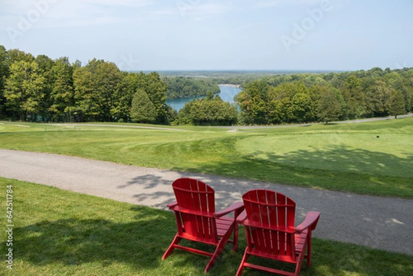 Obraz View of Green Lakes in Syracuse from the golf course.  Looking down onto the lake with 2 red outdoor chairs in the foreground. No people. 
