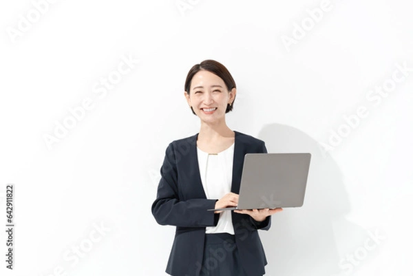 Fototapeta ノートパソコンを持つ笑顔のビジネスウーマン