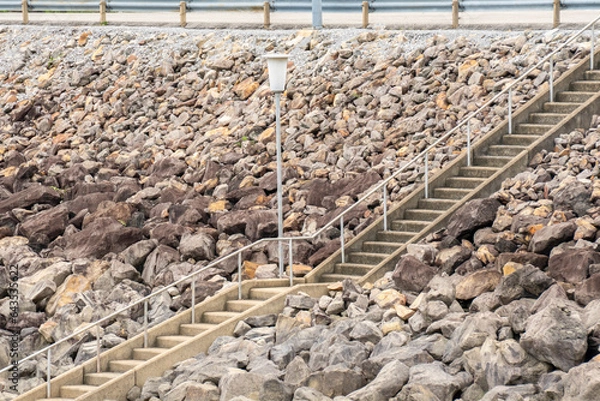 Fototapeta Sunlit Pathway Among Nature's Debris and Rocks