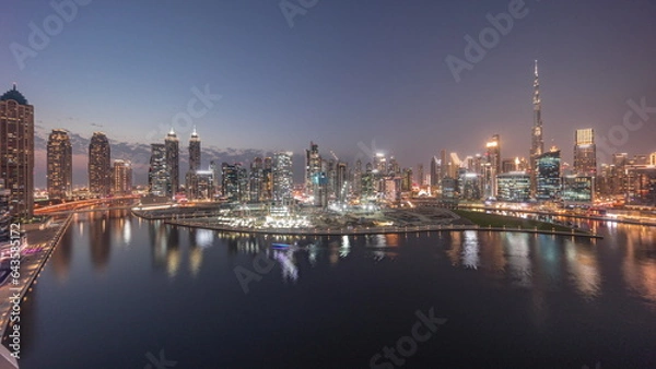 Fototapeta Aerial panorama of Dubai Business Bay and Downtown with the various skyscrapers and towers day to night timelapse