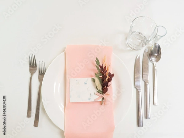 Fototapeta Setting the table for a wedding. Dishes, white tablecloth, flowers. Space for text. Decor. Holiday. Top view. High quality photo