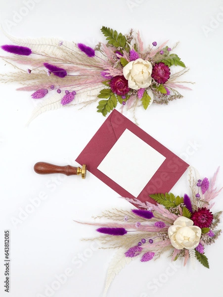 Fototapeta Flatley of natural flowers, burgundy envelope and greeting card, seal on white background, top view, space for text. Decor. Welcome card. High quality photo
