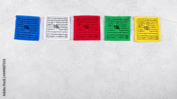 Obraz Colorful Tibetan buddhist prayer flags with mantras by Nepal on a grey background, copy space, top view. Tibetan prayer flags have five colors representing the elements or energies in nature