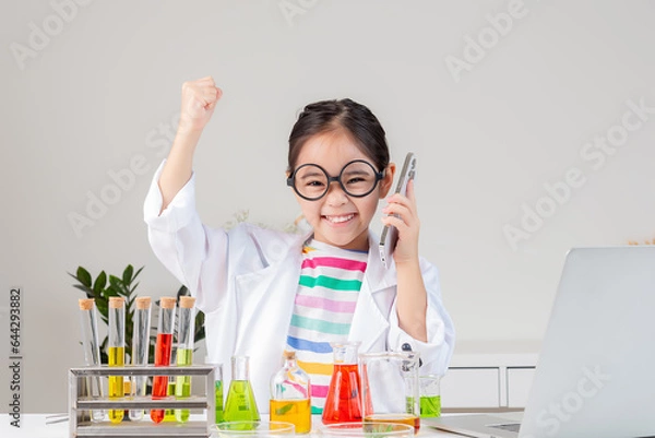 Obraz Asian little girl working with test tube science experiment in white classroom
