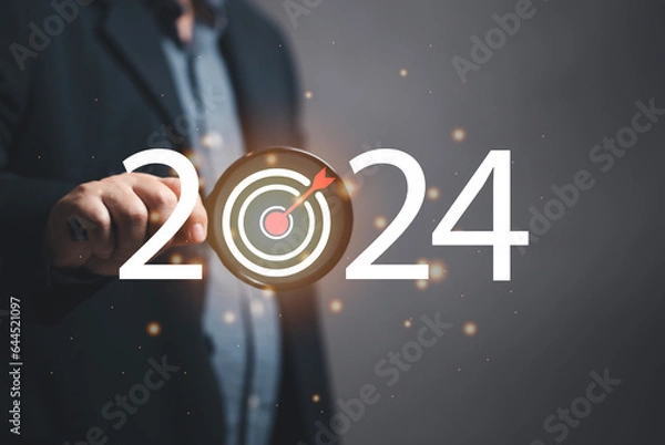 Fototapeta Marketer holding a magnifying glass to focus on marketing goals for 2024, setting marketing goals for next year. organization growth Setting guidelines for doing business. Marketing strategy and goal.
