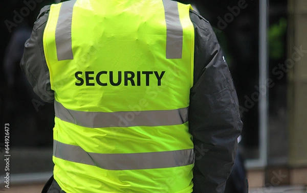 Fototapeta A security guard wearing a high vis vest