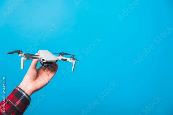 Fototapeta Drone quadcopter for aerial footage isolated in blue background 