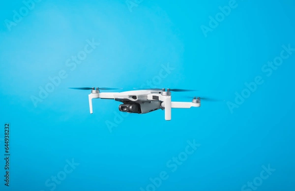 Fototapeta Drone quadcopter for aerial footage isolated in blue background 