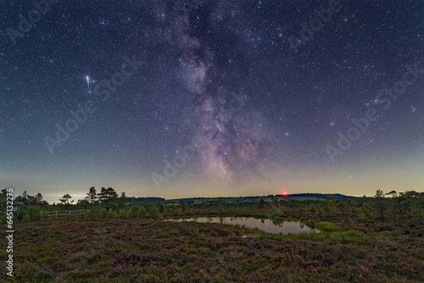 Obraz Meteor and the Milky Way over the Black Moor located in the Rhoen Biosphere Reserve in Germany.