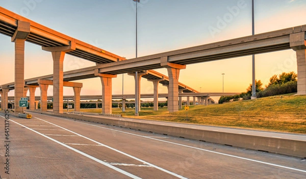 Fototapeta Elevated highways crossing on top of each others at sunset. Modern roads and bridges in Texas at golden hour