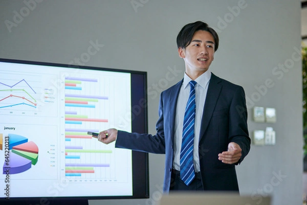 Fototapeta 会議室にてプレゼンテーションを行う若い日本人ビジネスマン