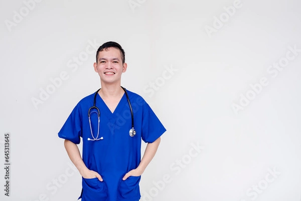 Obraz Portrait of a young and skilled medical student, nurse, intern posing with both hands inside pockets. Isolated on a white background.