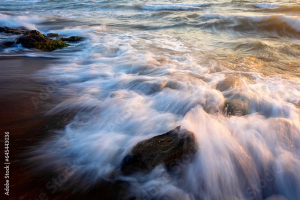 Fototapeta Sunset and sea rocks. Photo taken with the long exposure technique.