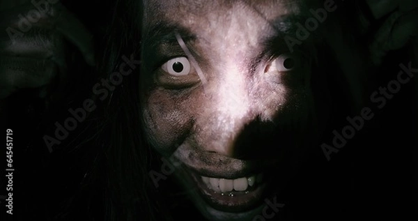 Obraz Horror scene of a mysterious Scary closeup eyes Asian ghost woman creepy have hair covering the face looking to camera at abandoned house with background dark scene movie at night, festival Halloween