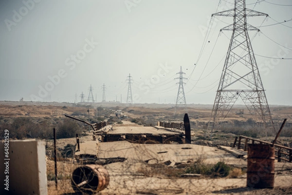 Obraz King Hussein Bridge: barbed wire, a damaged bridge and a long row of electric poles