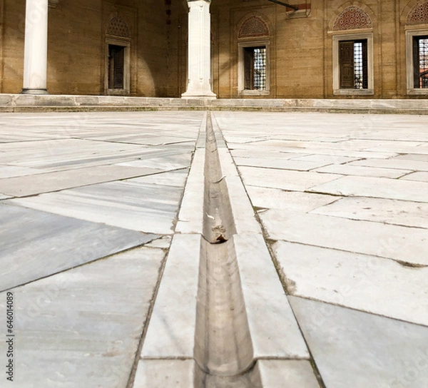 Obraz In terms of perspective, the stone arched domed mosque in the marble courtyard, shot from the ground and in focus, offers an aesthetic and historical view.