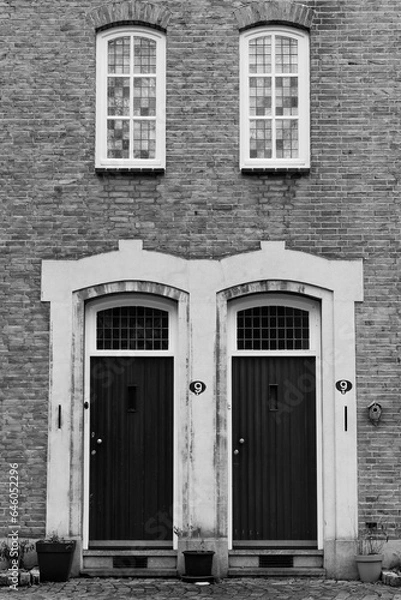 Obraz Black and white version of a historic facade with twin doors and windows entirely in symmetry.