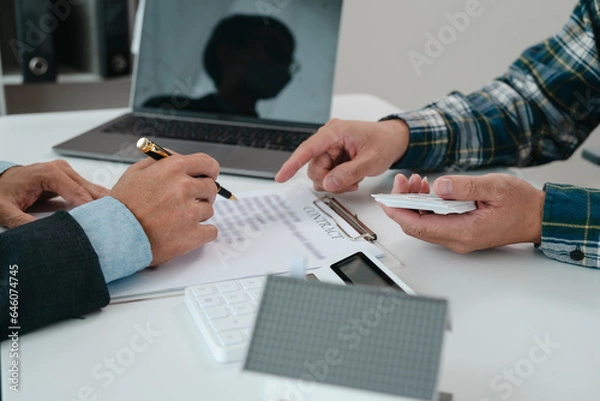 Fototapeta A real estate agent is talking with a client about buying a home or getting home insurance. Real estate agent buys, sells a house, agrees to buy a house.
