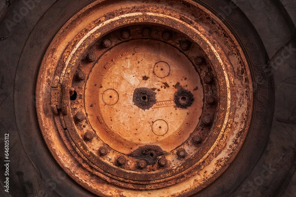 Fototapeta Full frame circular background texture of the huge rubber tire and rusted rim of an old mining truck