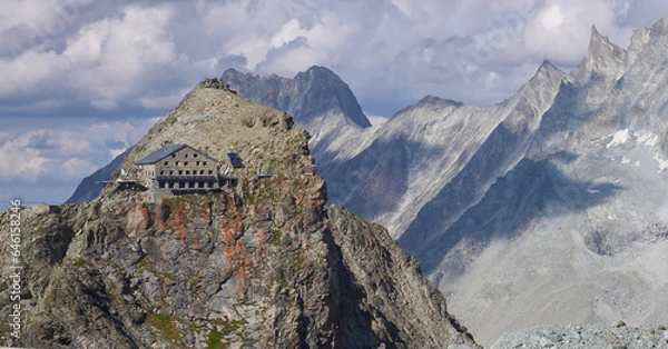 Fototapeta The Vignettes hut, an alpine Swiss mountain hut on the Glacier Haute Route from Chamonix to Zermatt. A breathtaking view on the Hut located at the edge of the mountain.