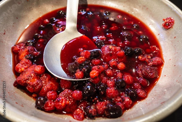 Fototapeta A mixed red, summer fruit compote in a bowl with a serving spoon, part of a self service breakfast buffet at a hotel.
