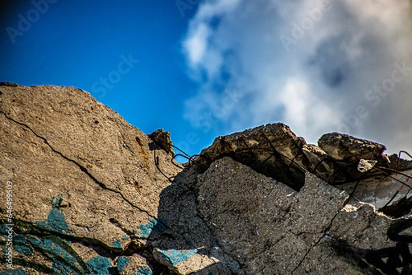 Fototapeta Collapsed stones of a building against the background of clouds and sky