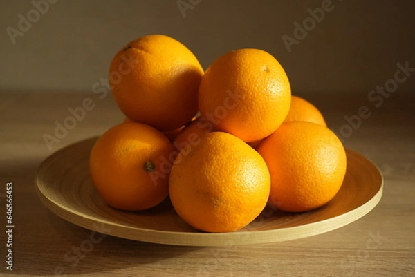 Fototapeta Several juicy oranges in a plate