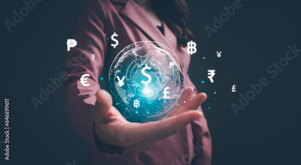 Fototapeta Businesswoman hand holding virtual world with international currency include dollar yuan yen euro and pound sterling sign. Concept of global currency exchange, money transfer and forex by technology.