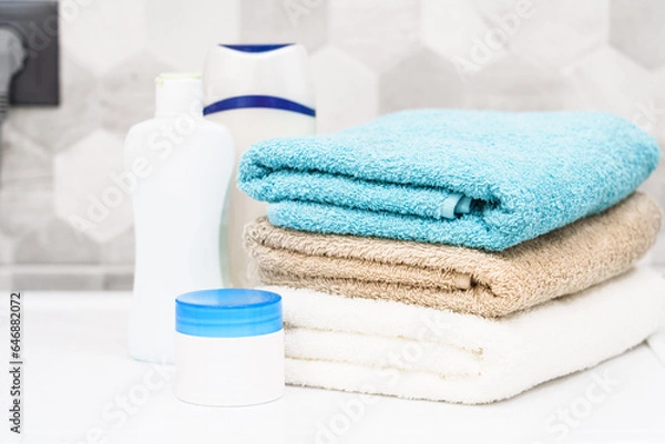 Obraz Clean towels and cosmetic products at the washing machine in the bathroom.