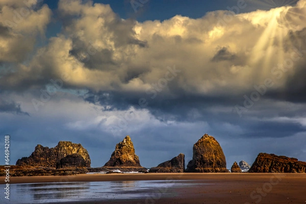 Fototapeta low tide rock formations with dramatic sun rays
