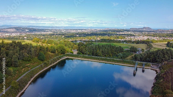 Fototapeta Scottish countryside - Reservoir Torduff and Edinburgh view from the sky. A small elongated reservoir retained by an earth embankment dam in the City of Edinburgh.