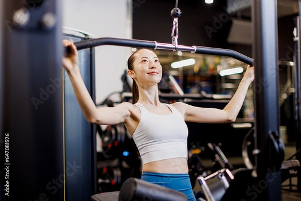 Fototapeta ラットプーリーで運動する若いアジアの女性