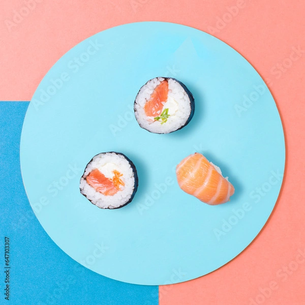 Fototapeta Japanense sushi rolls with salmon on a plate, top view