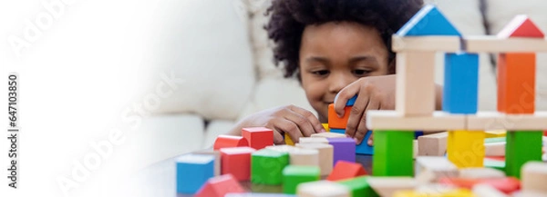 Fototapeta Little boy hands of little children play blocks in classroom. Learning by playing education group study concept. International pupils do activities brain training in primary school background banner