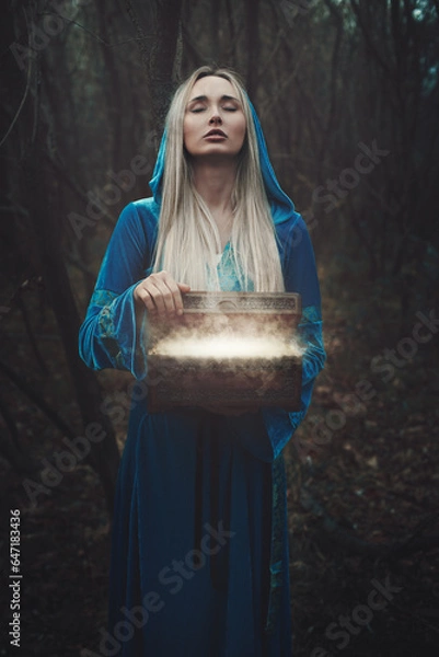 Fototapeta Woman opens a magical box in the forest