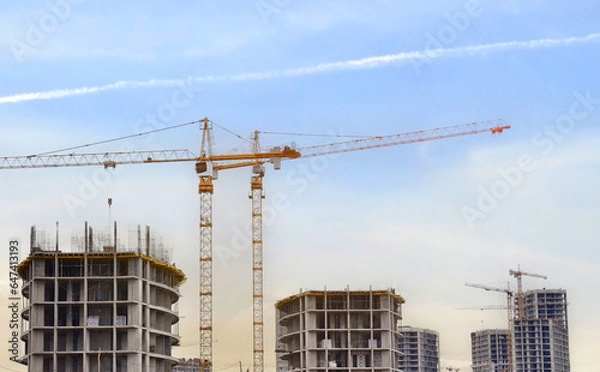 Fototapeta Construction site with tower crane. House and buildings construction. Hotel apartments construction. Housing renovation, real estate. Crane on formwork in Built environment. Cranes on pouring concrete