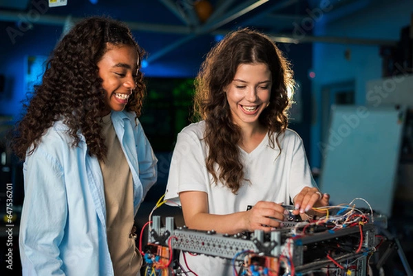 Obraz Two young women doing experiments in robotics in a laboratory
