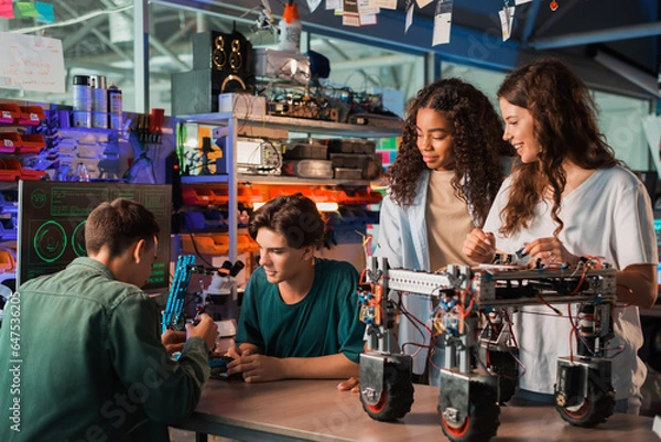Obraz Group of young people doing experiments in robotics in a laboratory