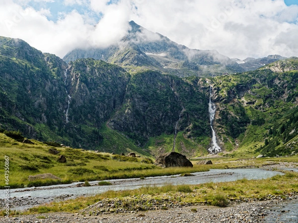 Fototapeta Sulzenaufall waterfall in the Stubai Alps in Austria. A green valley, rocky mountains and a powerful waterfall