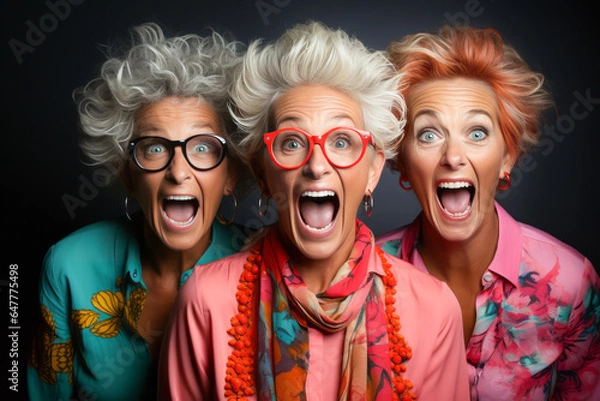 Fototapeta Funny portrait of three old shocked women looking at camera keeping mouth open. Sudden incredible news reaction wow.