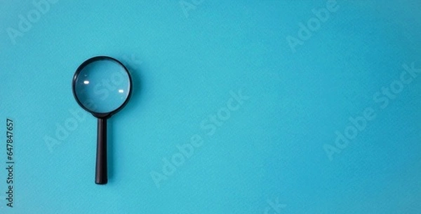 Obraz Magnifying glass, magnifying glass in a black frame on a blue background.  Concept research, objects magnification.  Flat top view.  Space for copying text.
