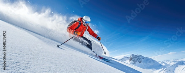 Obraz Skier carving down a powdery slope against a clear blue sky