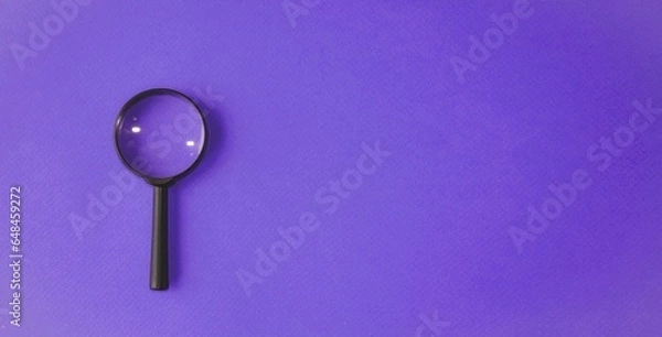 Obraz Magnifying glass, magnifying glass in a black frame on a purple, blue background.  Concept research, objects magnification.  Flat top view.  Space for copying text.