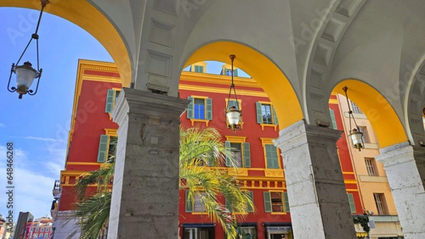 Fototapeta Architectural elements, red buildings, curves and arches of the city. Place Massena, during the day. Nice city, France