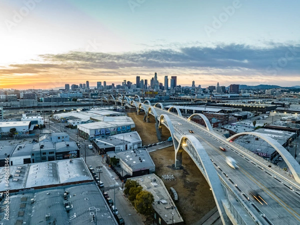 Obraz Aerial panoramic view of industrial urban borough and modern road bridge. Skyline with downtown skyscrapers against sunset sky. Los Angeles, California, USA