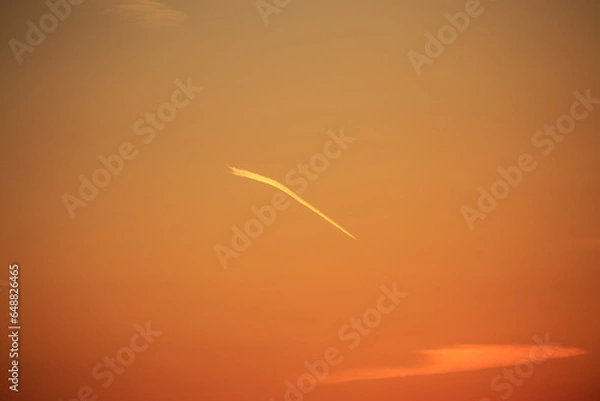 Fototapeta 夕焼けを切り裂く飛行機雲