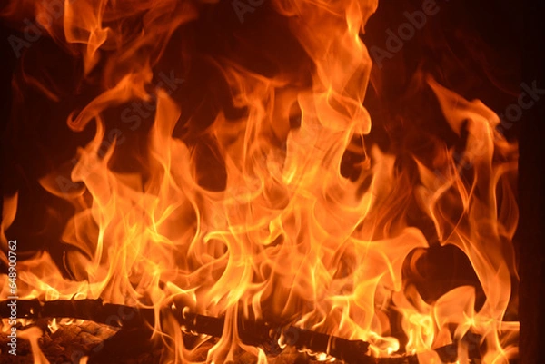 Fototapeta Fire creates infinite shapes when it burns. The orange of the flame and the black background create interesting textures. Flames of hell. Burning power. Fire in a wood oven