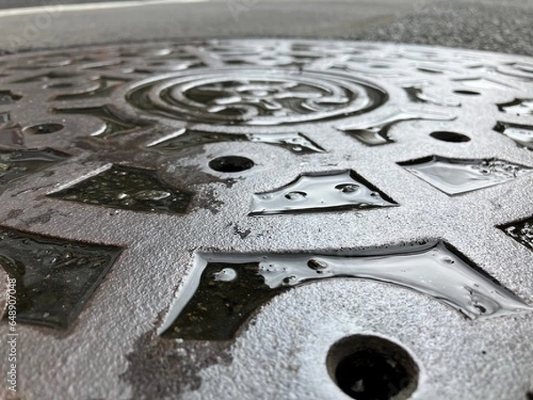 Fototapeta 雨に濡れたマンホールの蓋のアップ