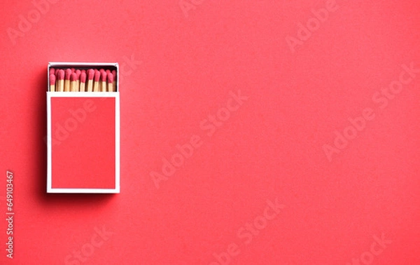 Fototapeta red matchstick in red matchbox on red paper background with copy space