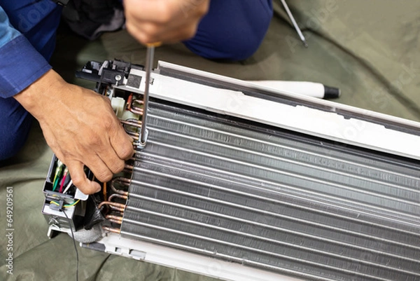 Obraz Technician is fixing or checking the evaporator system, troubleshooting air conditioning unit or dismantling for air conditioner fan coil unit cleaning,repair and maintenance,install air conditioner